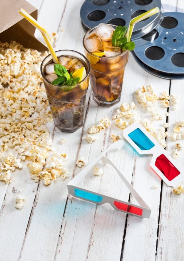 Popcorn, sodas, 3D glasses and film reel flat lay